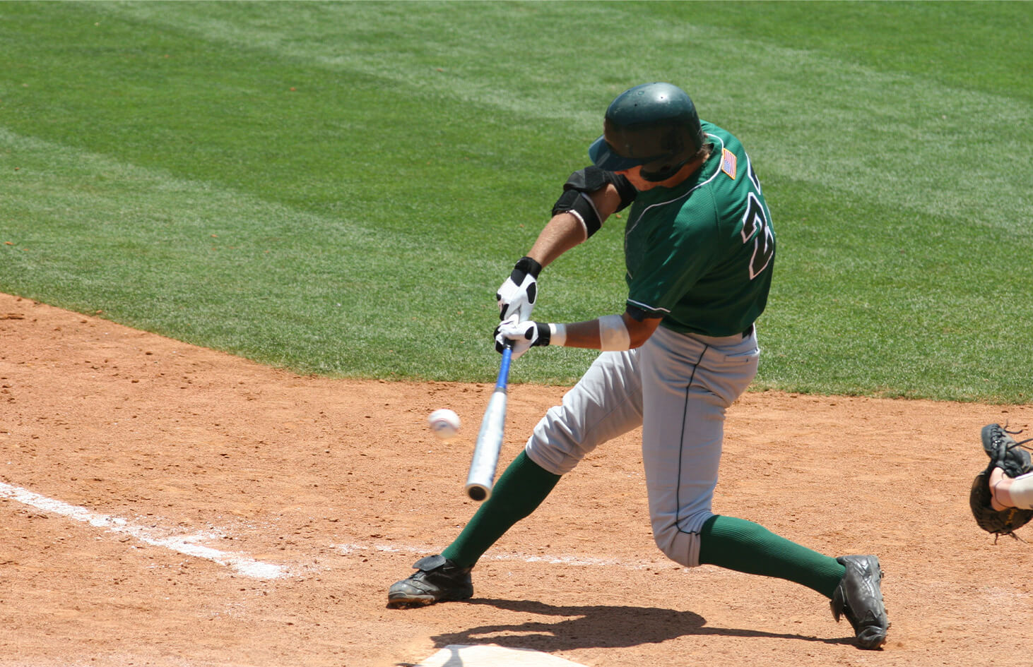 Baseball player swinging and hitting a baseball