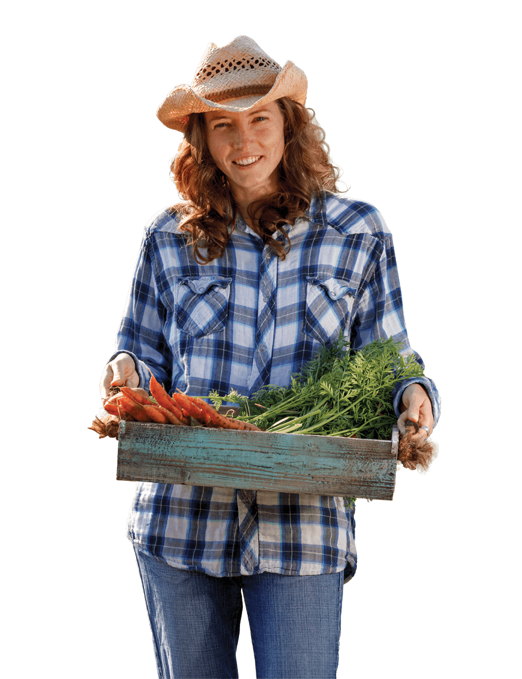 A woman carries a tray of crops from the field.