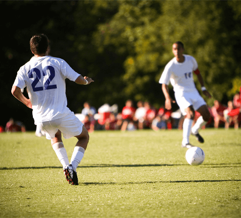 Soccer players passing the ball during a game